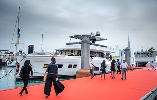 visitors stroll the red carpet boardwalk at the Dubai International Boat Show 