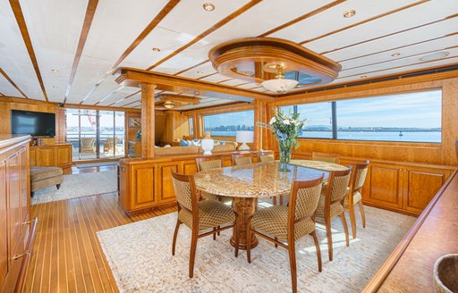 Formal interior dining area onboard charter yacht ALMOST THERE, surrounded by wide windows 