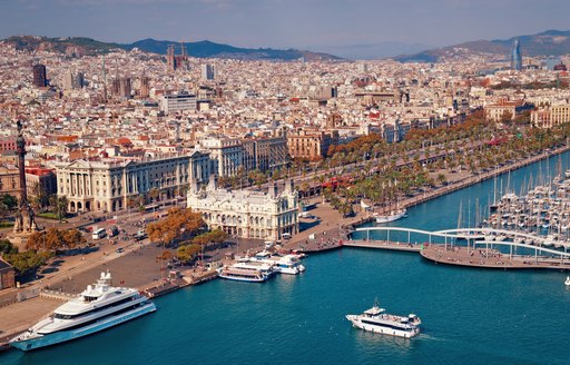 Barcelona skyline from the water with superyachts in shot