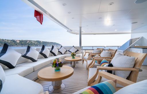 Exterior seating area with white sofa onboard charter yacht KAISER