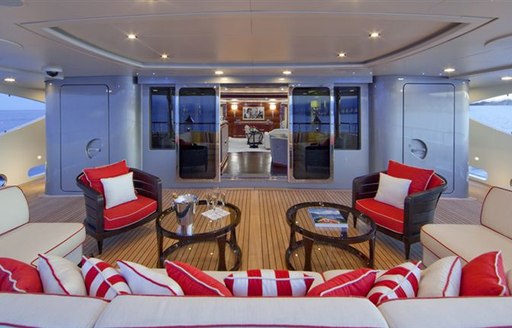 Red sofas and seats in the main deck aft area on superyacht LATITUDE