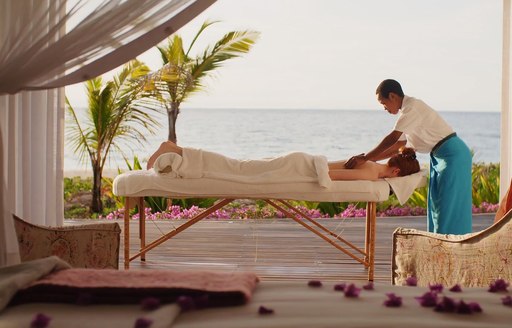 woman lays on table and receives a massage from staff on thanda island