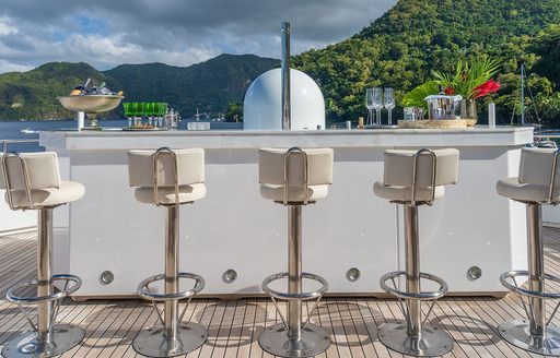 Exterior wet bar with stools onboard charter yacht OCEANOS
