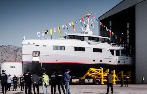 Charter yacht EMOTIONAL leaving construction shed with flags