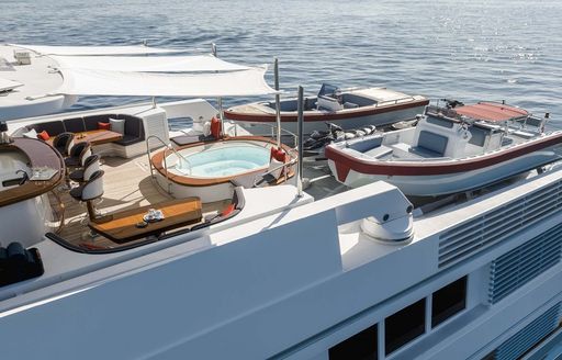 Sun deck overview onboard super yacht charter OLYMPUS, with a deck Jacuzzi and a tender