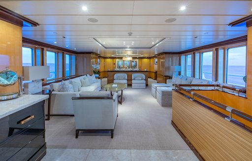 Main salon onboard yacht rental NITA K II with plush seating and many windows surrounding