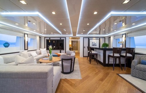 Overview of the interiors onboard charter yacht HOLDIN' MY OWN with sofas to port and a wet bar to starboard