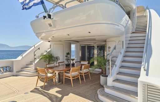 Charter yacht OASIS exterior deck psace with dining table and stairs