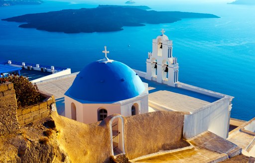 Blue domed chapels in Santorini, white buildings overlooking the sea