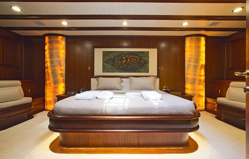 large bed and amber pillars in the master suite aboard sailing yacht Aria I 