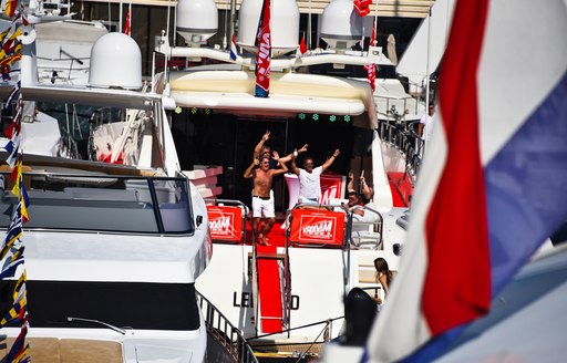 Group of charter guests onboard motoryacht, cheering and celebrating at Monaco Grand Prix.