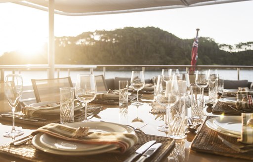 al fresco dining table is set up for dinner on the upper deck aft of charter yacht RELENTLESS 