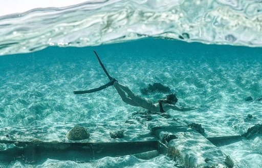 Underwater shot of woman snorkeling by Pablo Escobar's plane 