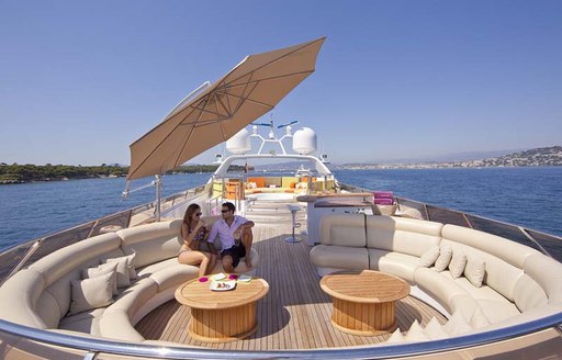 luxury charter yacht daloli, sundeck with circle seating and coffee tables and umbrellas