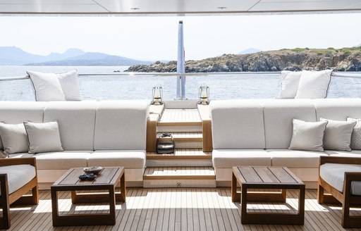 Aft deck of motor yacht IRISHA, with coffee tables and white sunpads