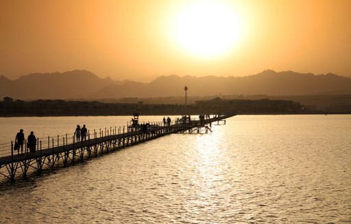 Long bridge over calm water at sunset