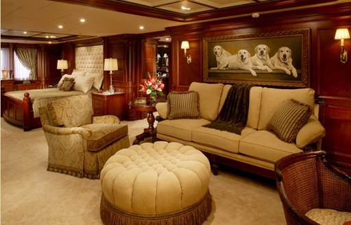 Master cabin lounge area with plush cream seating against dark wood