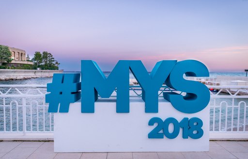 Logo of MYS 2018 in front of pink and blue background