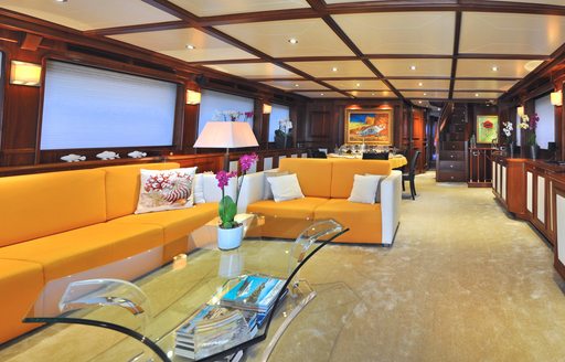 Yellow sofas and cream carpet in main salon of yacht CONQUISTADOR