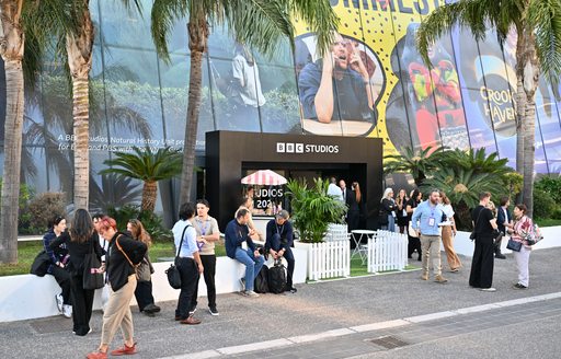 BBC exhibit and visitors walking by at MIPCOM Cannes