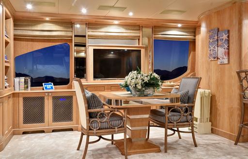 Interior seating with table and facing chairs onboard charter yacht QUEST R