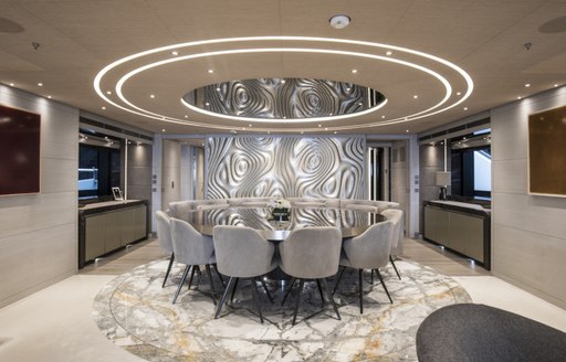 dining set up on superyacht severins, with marble flooring and light on ceiling