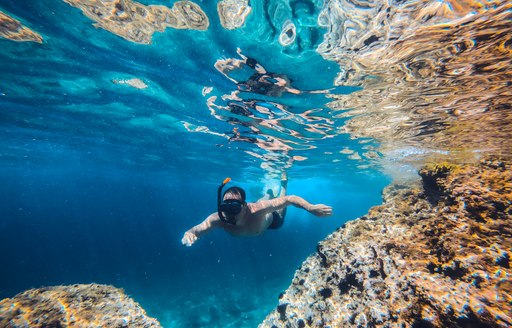 a woman snorkelling through crystal clear waters 