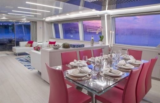 interior dining area with stainless steel table and bright pink chairs on board superyacht Alandrea