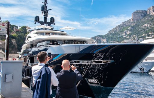 MYS visitors on the dock taking photos of a berthed superyacht