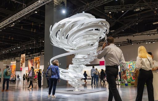 Art sculpture on display at Art Basel Miami with visitors walking around