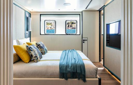 Double guest cabin onboard charter yacht RIO with central berth and wall-mounted TV opposite