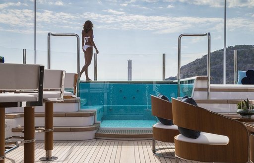 A charter guest approaches the Jacuzzi featured on board superyacht AQUILA