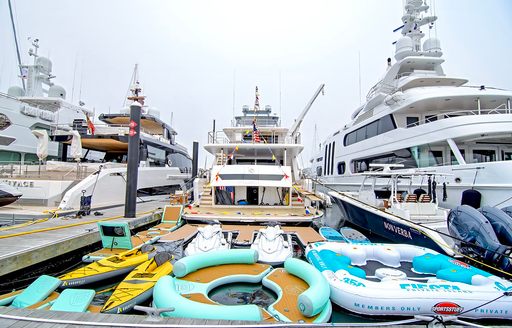 Aft view lineup of motor yacht charters berthed with water toys on display
