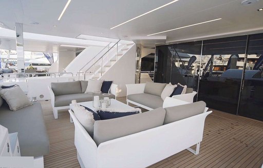 Covered sofa and table on deck of motor yacht Aqua Life