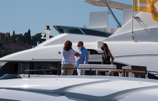 Visitors with masks view a yacht in-show at the MYS 2021