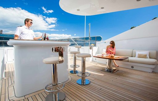 Sundeck of superyacht DIANE, with charter guest enjoying cocktail