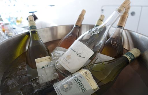 bottles of white and rose wine in an ice bucket on board a superyacht hosting guests for the Monaco Grand Prix