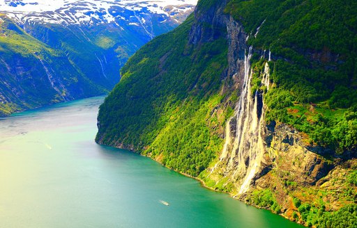 The steep and green landscape of the Norwegian fjords.