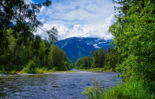 Overview of Bella Coola, British Colombia, with a river in the foreground and mountains in the background