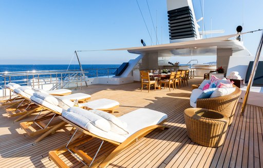 Feadship charter yacht W sundeck with loungers and dining area