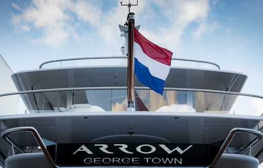 the ensign of charter yacht arrow with the french flag as it cruises the Mediterranean waters 