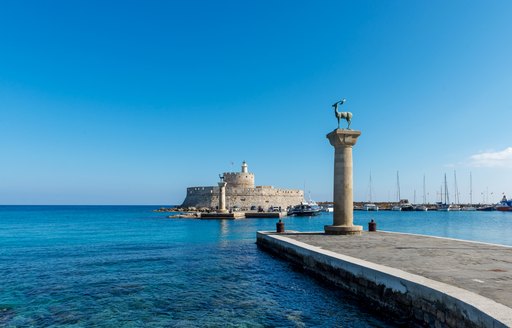 entrance to rhodes harbour with monument 