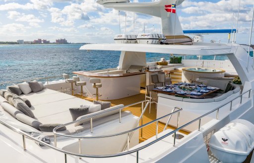 Overview of the sun deck onboard charter yacht ZEXPLORER, sun pads aft with a wet bar amidships.