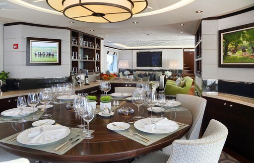 Detailed shot of dining salon on charter yacht AURELIA, with pictures hanging on walls and warm light fixture above