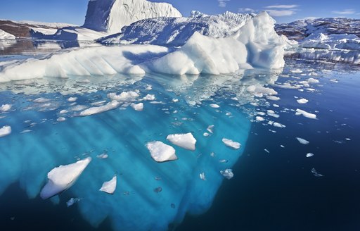 Glacier in fjord in Greenland, icebergs dotted around