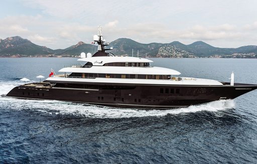 Charter yacht LOON underway, surrounded by sea with an island in the background