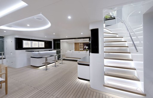 Semi al fresco deck space with bar and steps on board luxury yacht Liquid Sky 