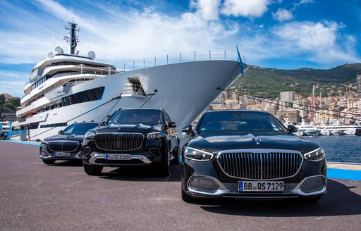 Trio of black cars on the dock adjacent to luxury charter yacht RENAISSANCE