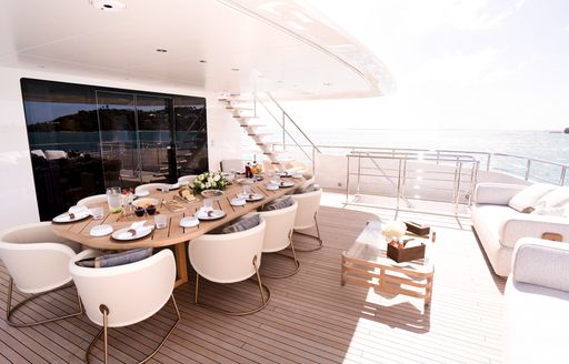 Alfresco dining onboard charter yacht RELIANCE, long table seat for a meal with white chairs