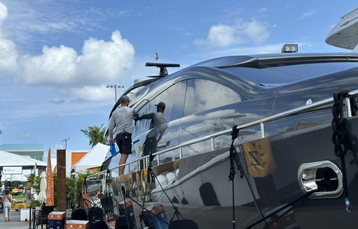 Motor yacht being cleaned by crew at FLIBS